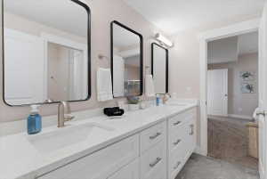 Bathroom featuring a dual vanity with white shaker cabinetry, rectangular undermount sinks, and brushed nickel faucets