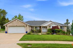Traditional ranch-style residence featuring a brick facade, attached two-car garage, and a concrete driveway