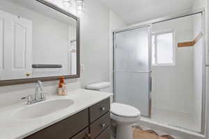Bathroom featuring a vanity with an integrated sink, a white countertop, and dark wood cabinetry
