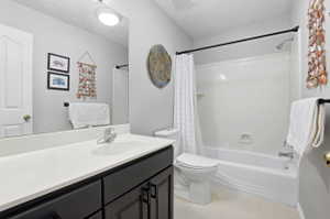 Bathroom featuring a single vanity with a white countertop, chrome faucet, and dark wood-finish cabinetry