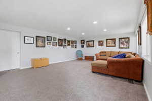 Spacious room with light gray walls, recessed lighting, and a neutral-toned carpet