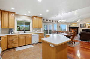 Open-concept living space featuring a kitchen with light wood cabinetry, white countertops, and a tile floor