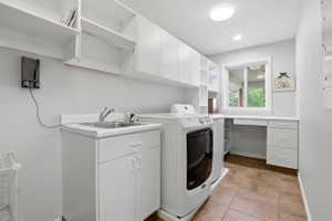 Utility room featuring white cabinetry, a built-in sink, and ample countertop space