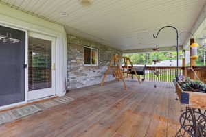 Expansive wood-finish deck with a solid wood railing system, an overhead solid roof, and recessed lighting