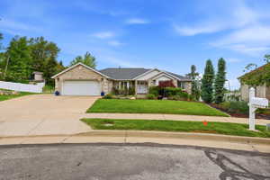 Ranch-style residence featuring a stone and siding exterior, a two-car garage, and a concrete driveway