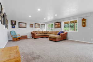 Spacious room with light gray walls, recessed lighting, and soft carpet flooring