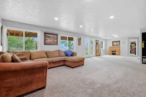 Spacious carpeted room featuring recessed lighting and multiple sliding glass doors