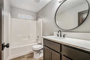 2nd Bathroom featuring a dark wood-finish vanity with a light countertop, an undermount sink, and a black-framed round mirror