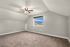 4th Bedroom - Carpeted room featuring a ceiling fan with integrated lighting, a window with a mountain backdrop, sloped ceilings, and white baseboards