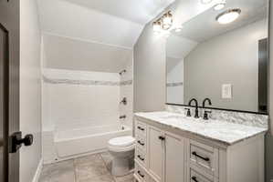 Bathroom featuring a vanity with a stone countertop, an undermount sink, and matte black fixtures