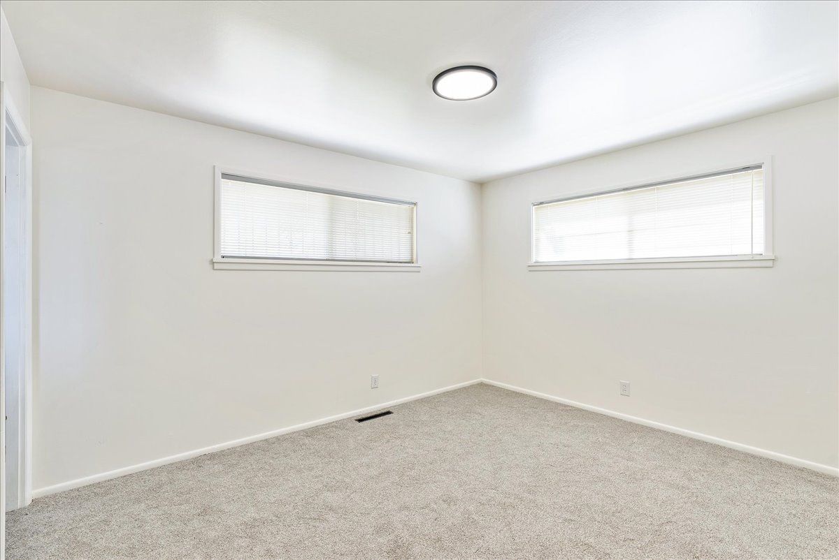 Room with neutral-toned carpet flooring, white baseboards, and light-colored walls