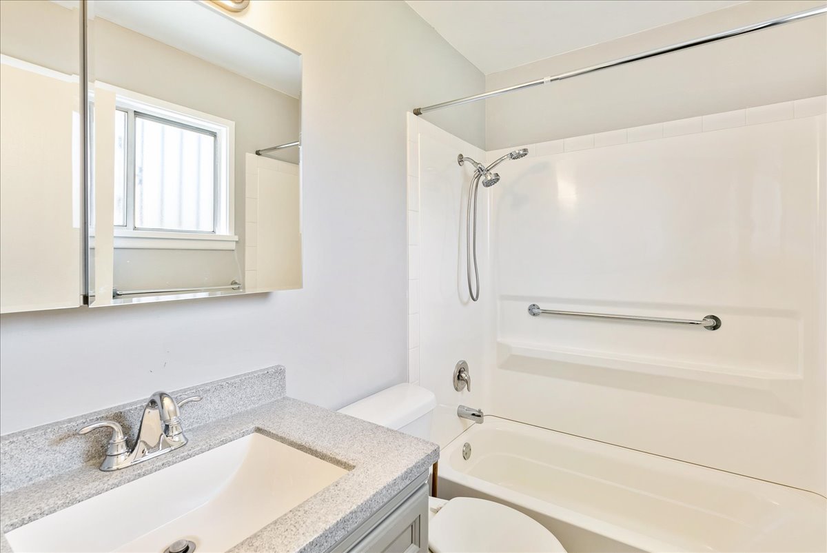 Bathroom featuring a modern vanity with a speckled countertop, a chrome faucet, and a large medicine cabinet