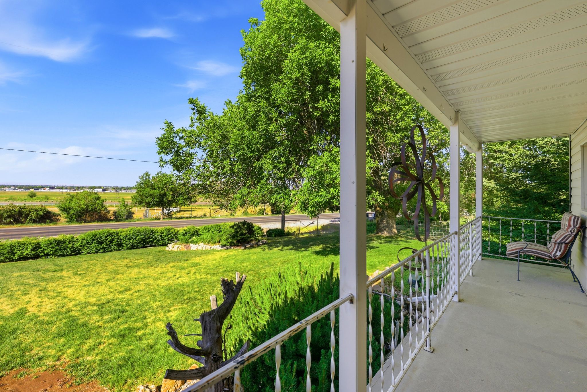 Covered front porch with white railings and columns