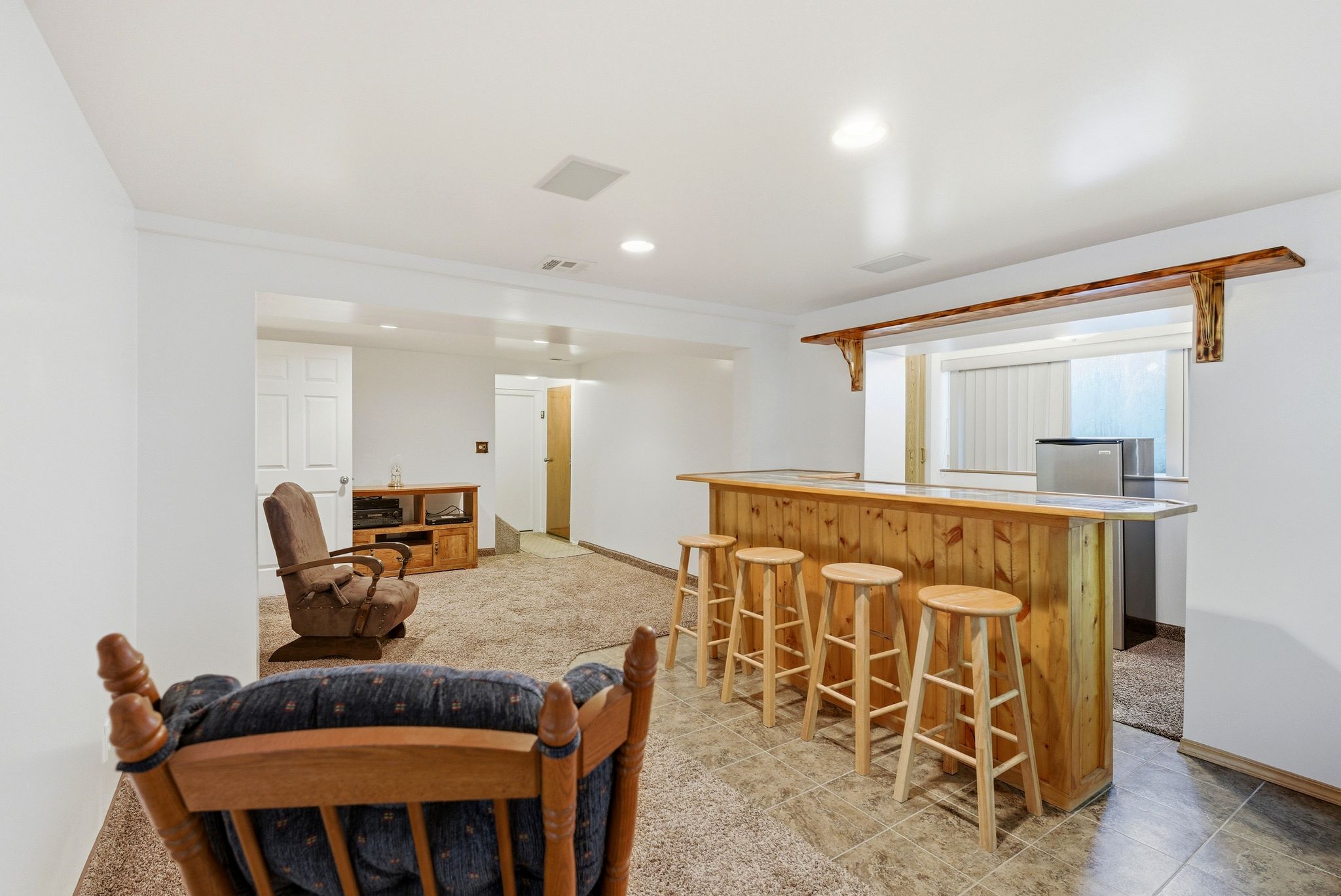Finished basement featuring a custom wood-paneled bar with integrated seating