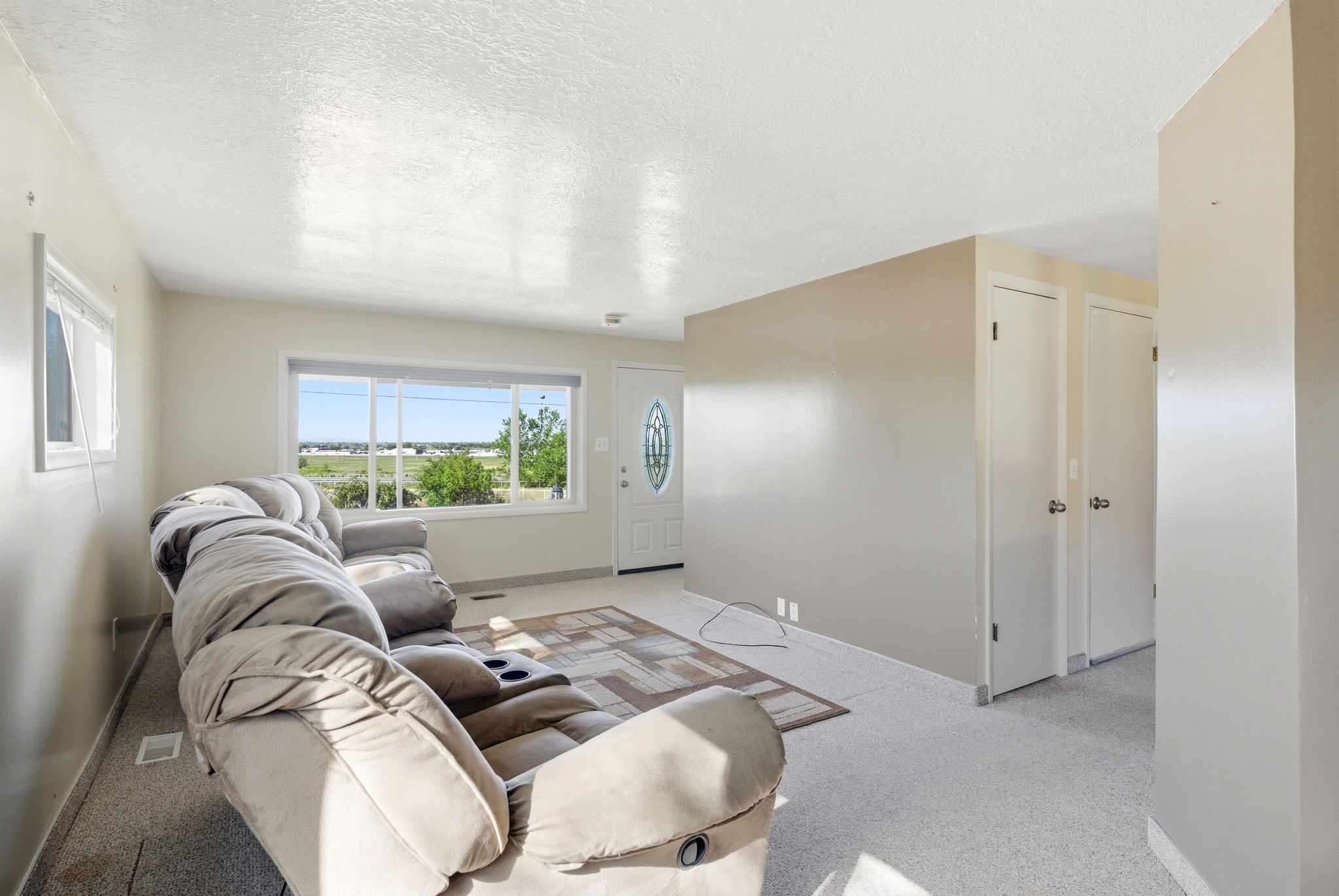Living area featuring light-colored walls and carpet flooring