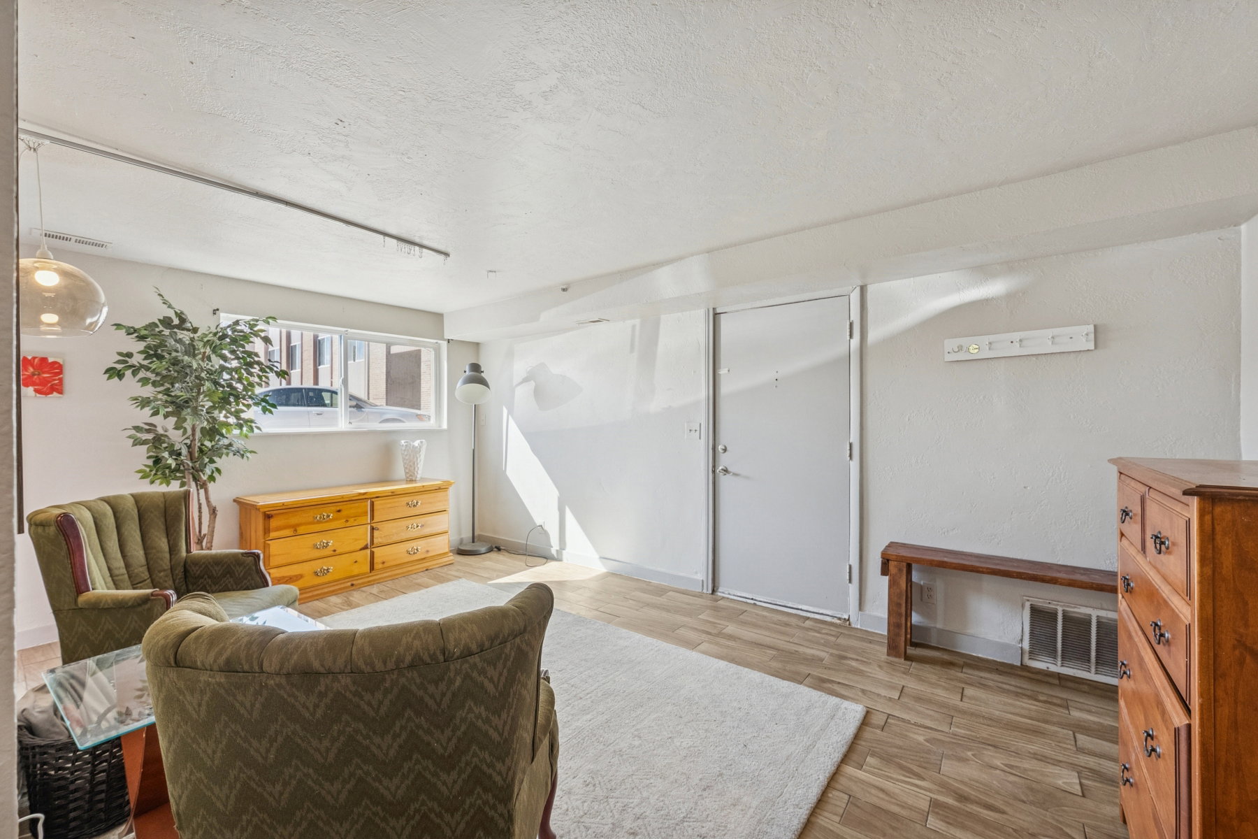 Living area featuring wood-finish flooring, white walls, and a large window