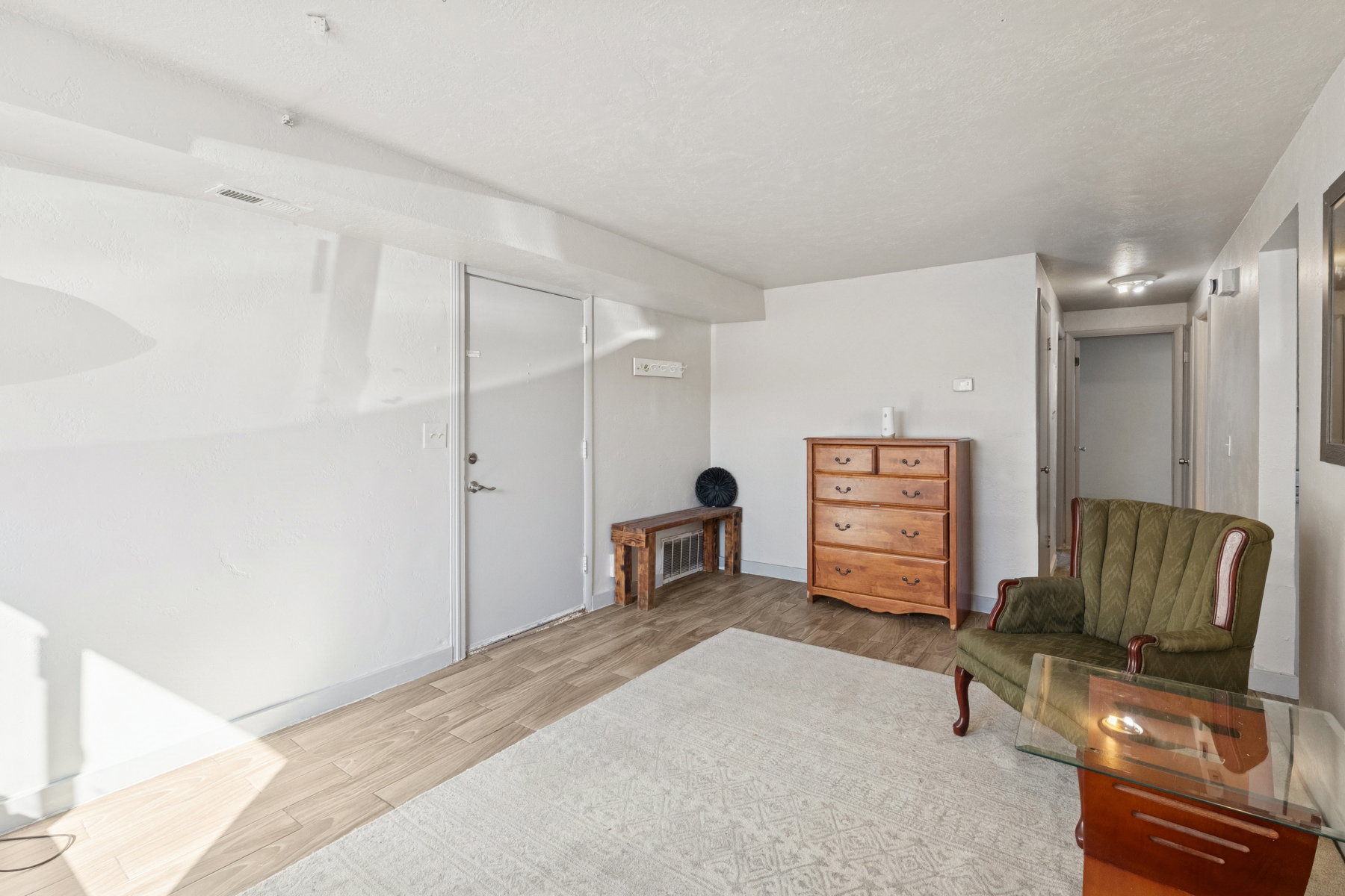 Bright room featuring light-toned wood-finish flooring, white walls, and a white ceiling