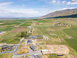 Aerial perspective of rural land featuring agricultural fields, distant mountains, and scattered residences