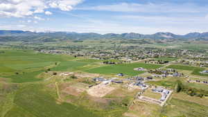 Expansive aerial view showcasing a rural landscape with distant snow-capped mountains