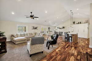 Spacious open-concept living area featuring a vaulted ceiling and recessed lighting