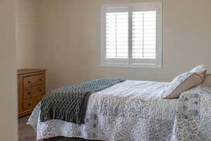 Interior room featuring neutral wall finishes, a window with plantation shutters, and carpet flooring
