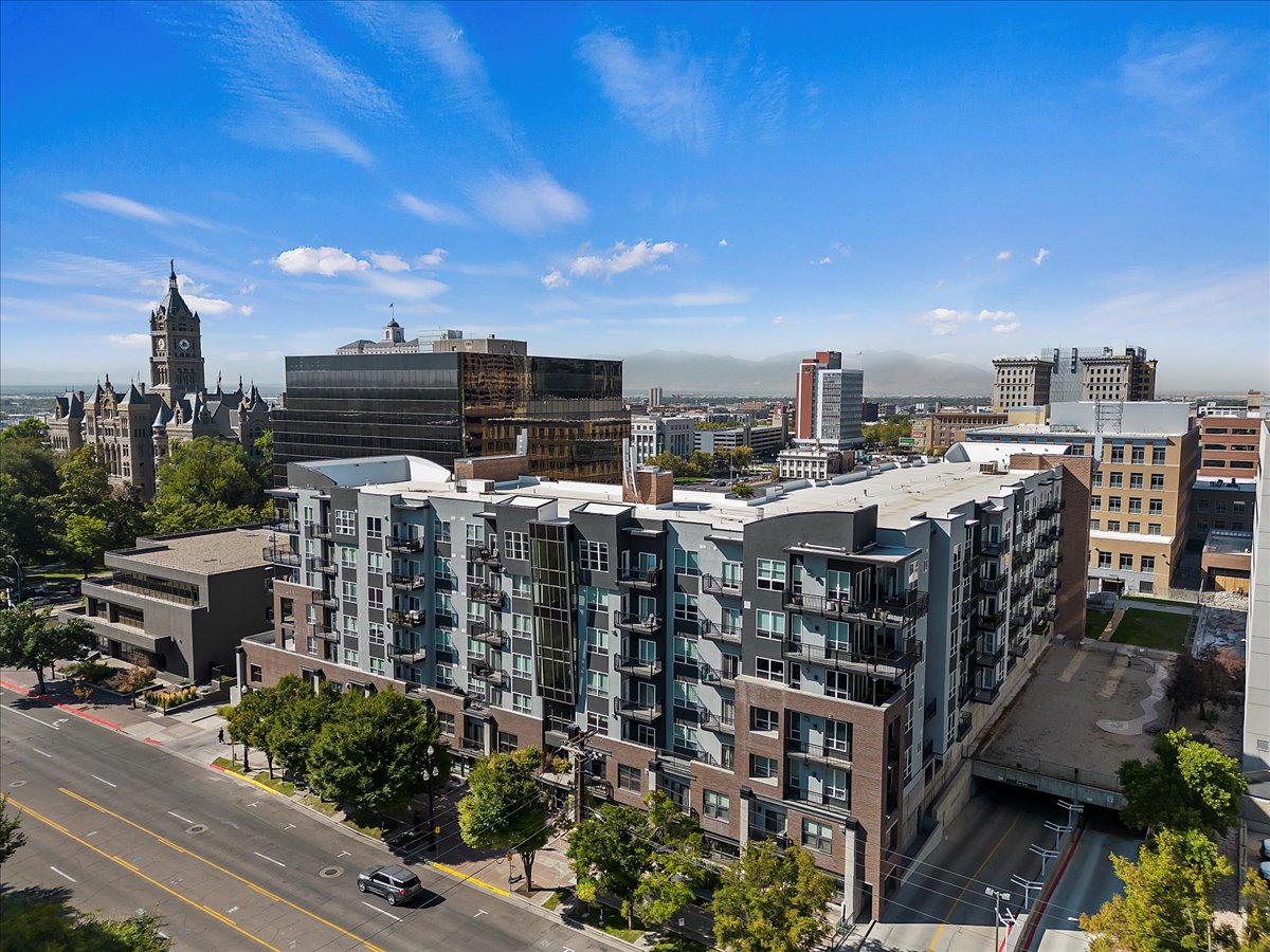 Modern multi-story building featuring balconies and a brick and panel facade