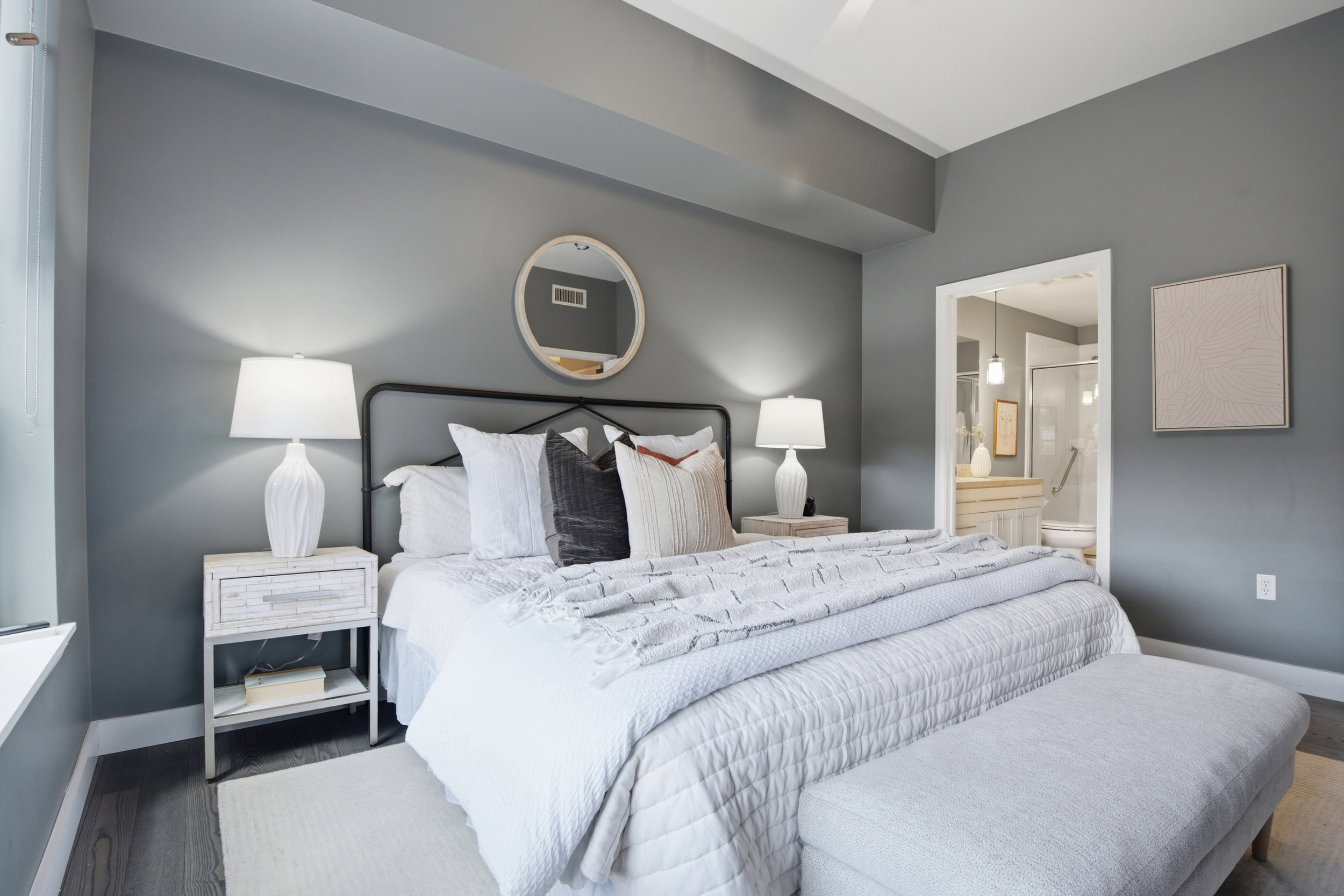 Contemporary bedroom featuring gray walls and wood-finish flooring