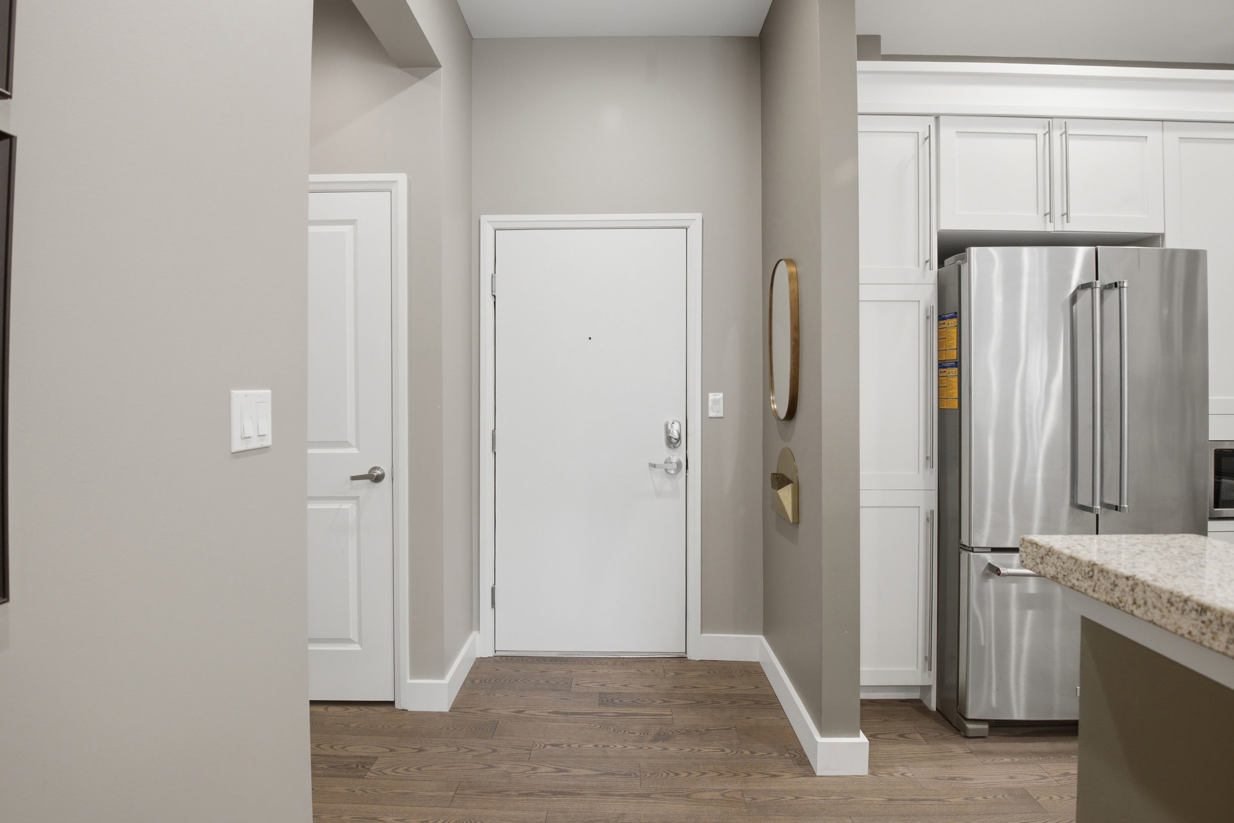 Entryway featuring wood-finish flooring, white trim, and a white interior door