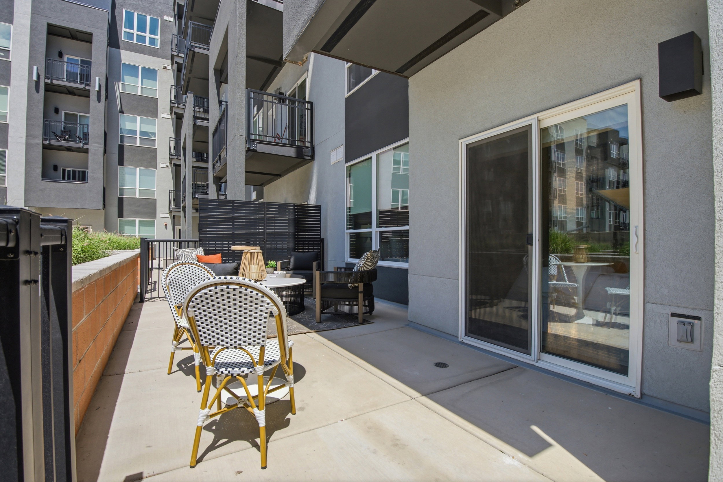 Private patio space featuring concrete flooring and a partial privacy screen