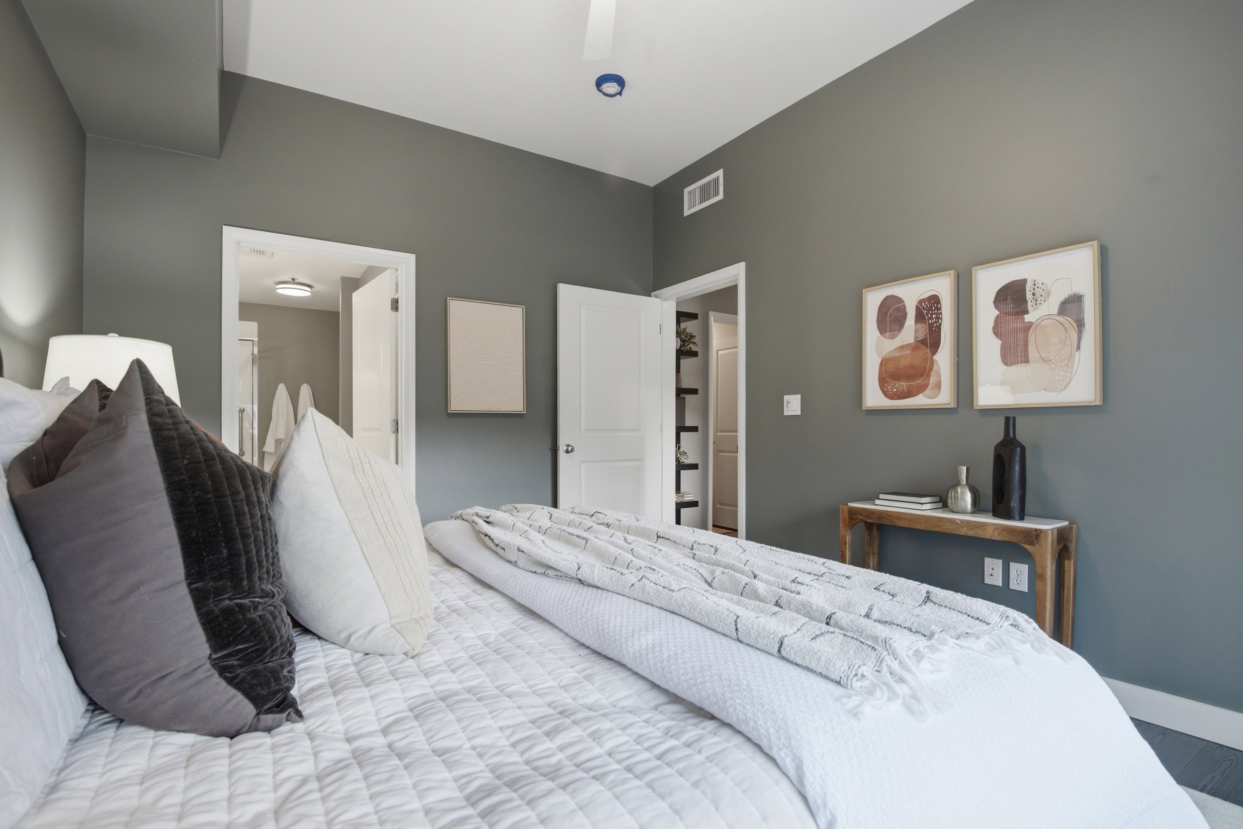 Spacious bedroom featuring neutral wall tones, a ceiling fan, and white trim