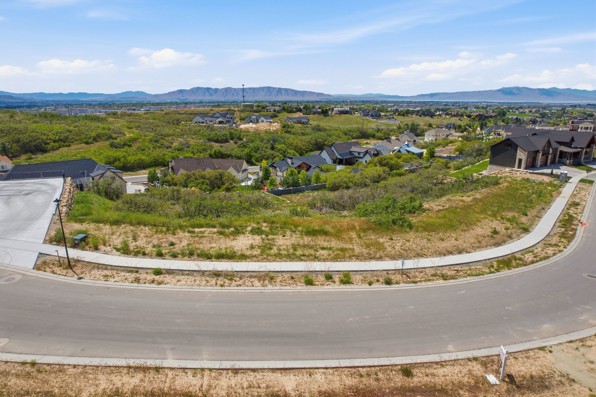 North/East facing View lot featuring a paved street and concrete sidewalks