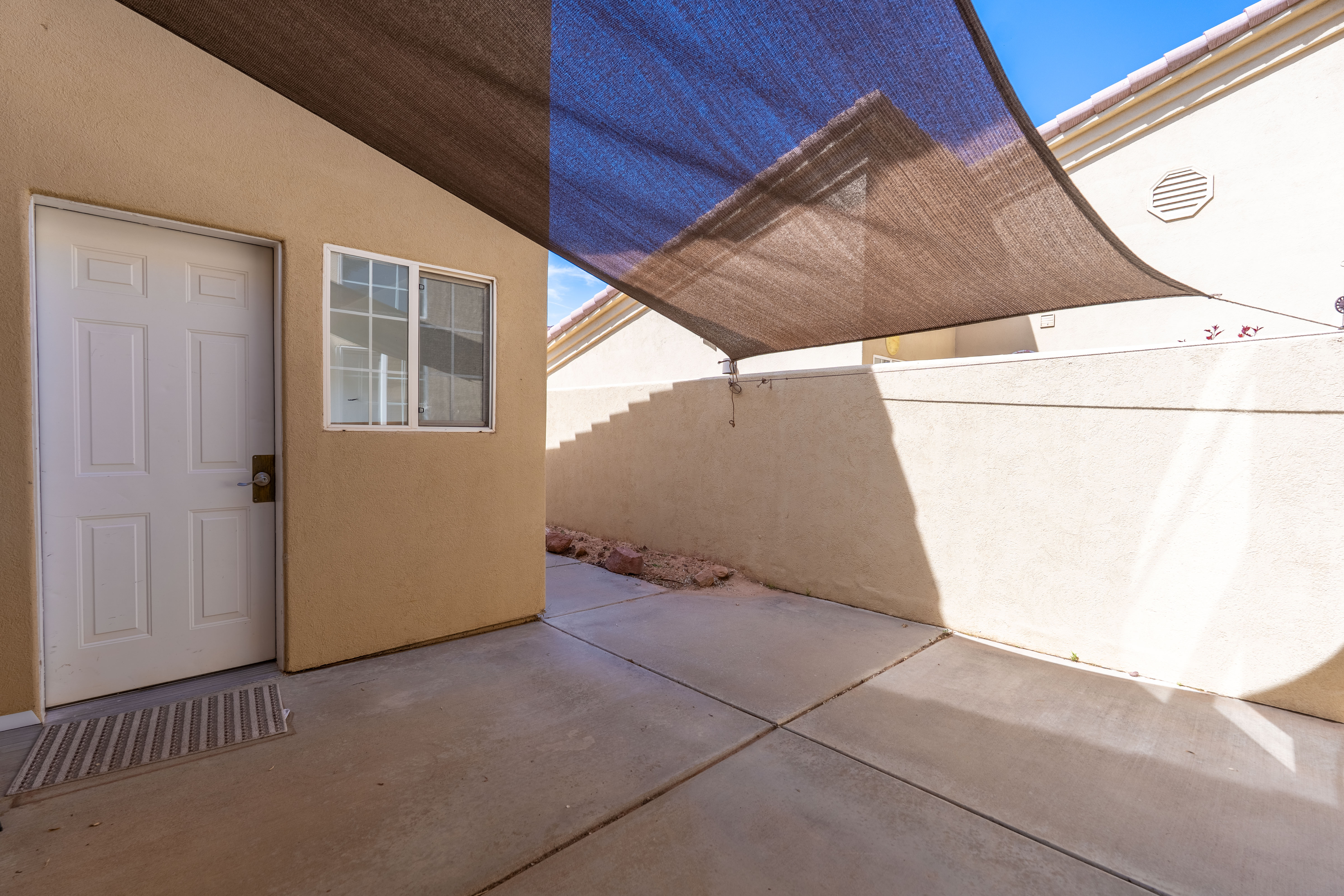 Private patio featuring a shade sail and concrete flooring