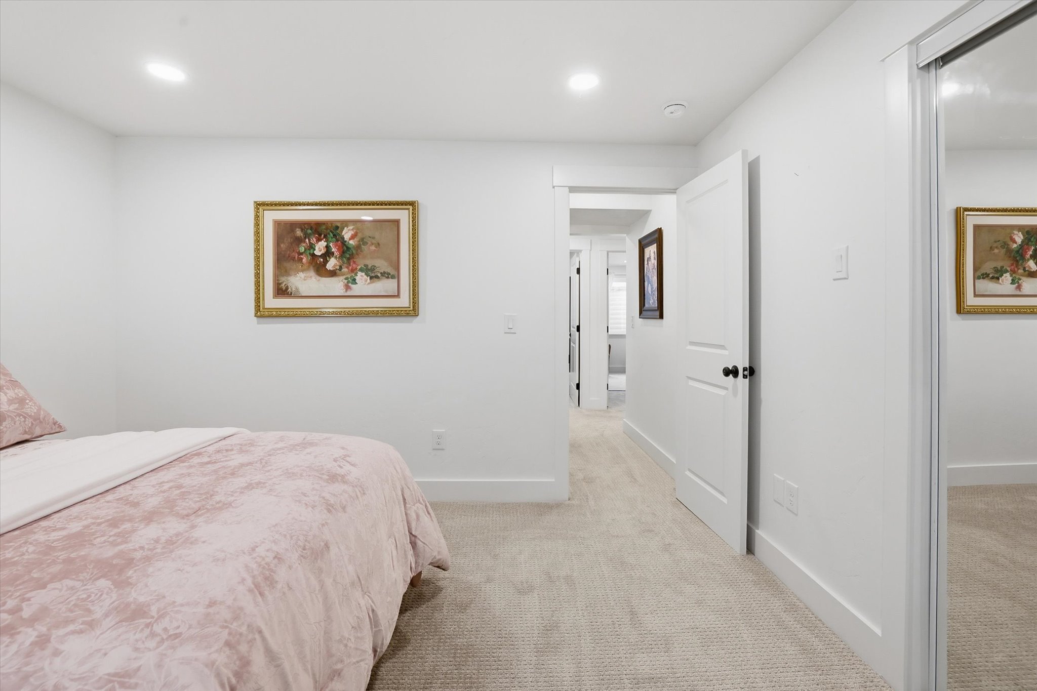 Carpeted room featuring white walls, recessed lighting, and a mirrored closet door
