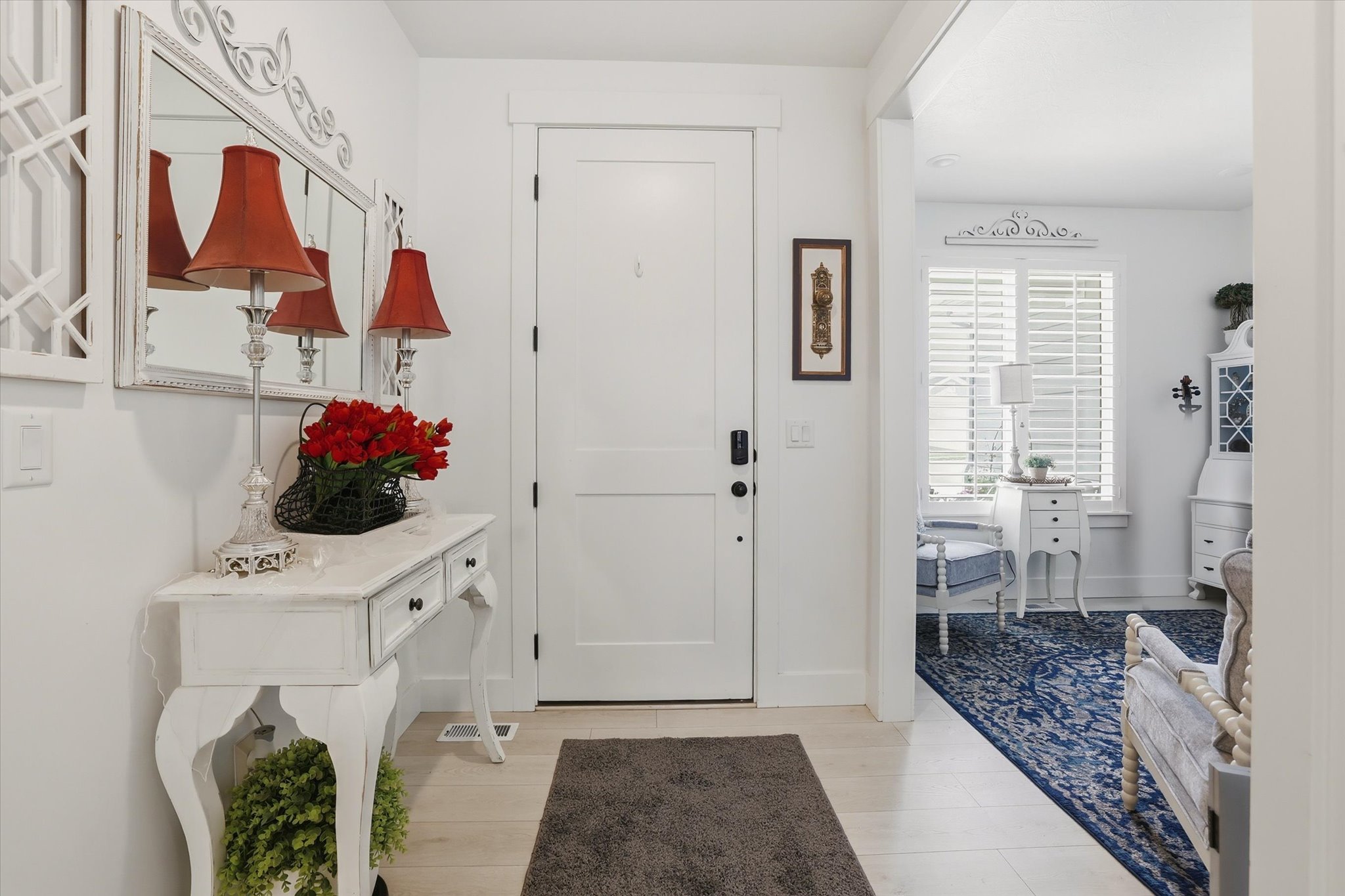 Entryway featuring a solid panel door with dark hardware, light wood-finish flooring, and a decorative console table