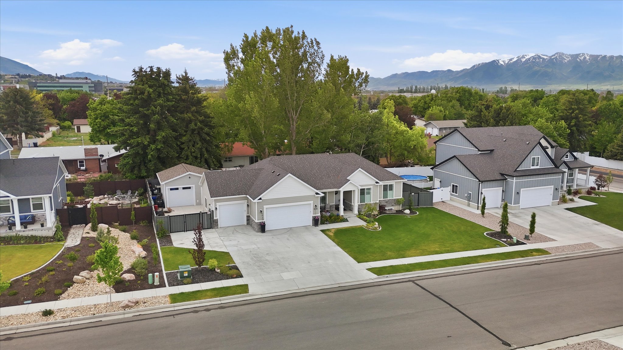 Contemporary single-story residence featuring light gray siding and dark roof shingles