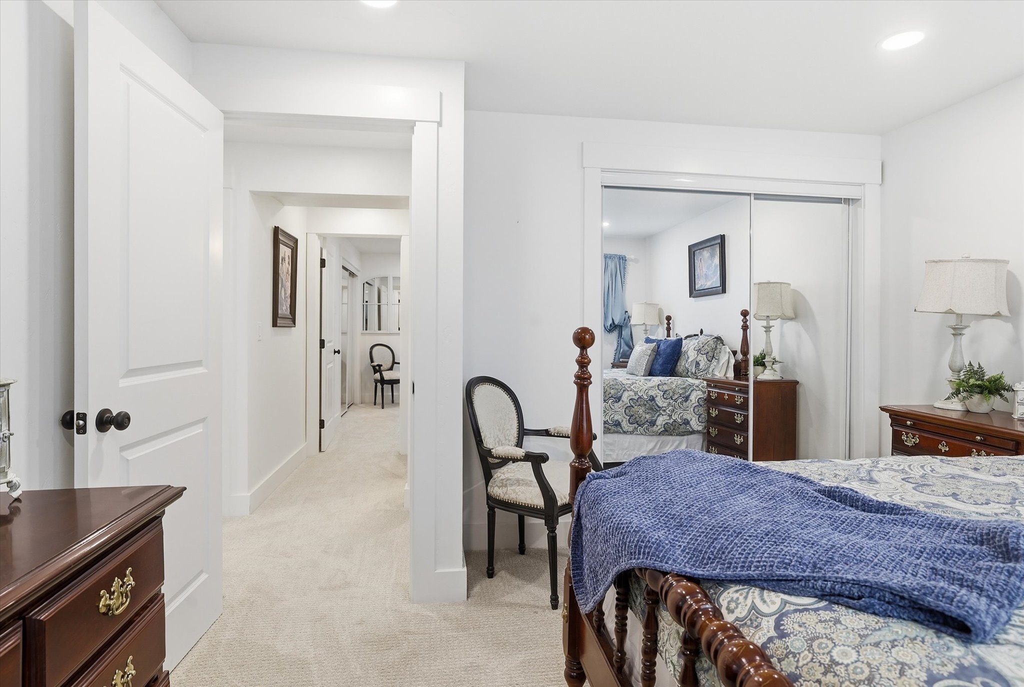 Bedroom featuring neutral-toned carpeting, white walls, and a mirrored closet with sliding doors
