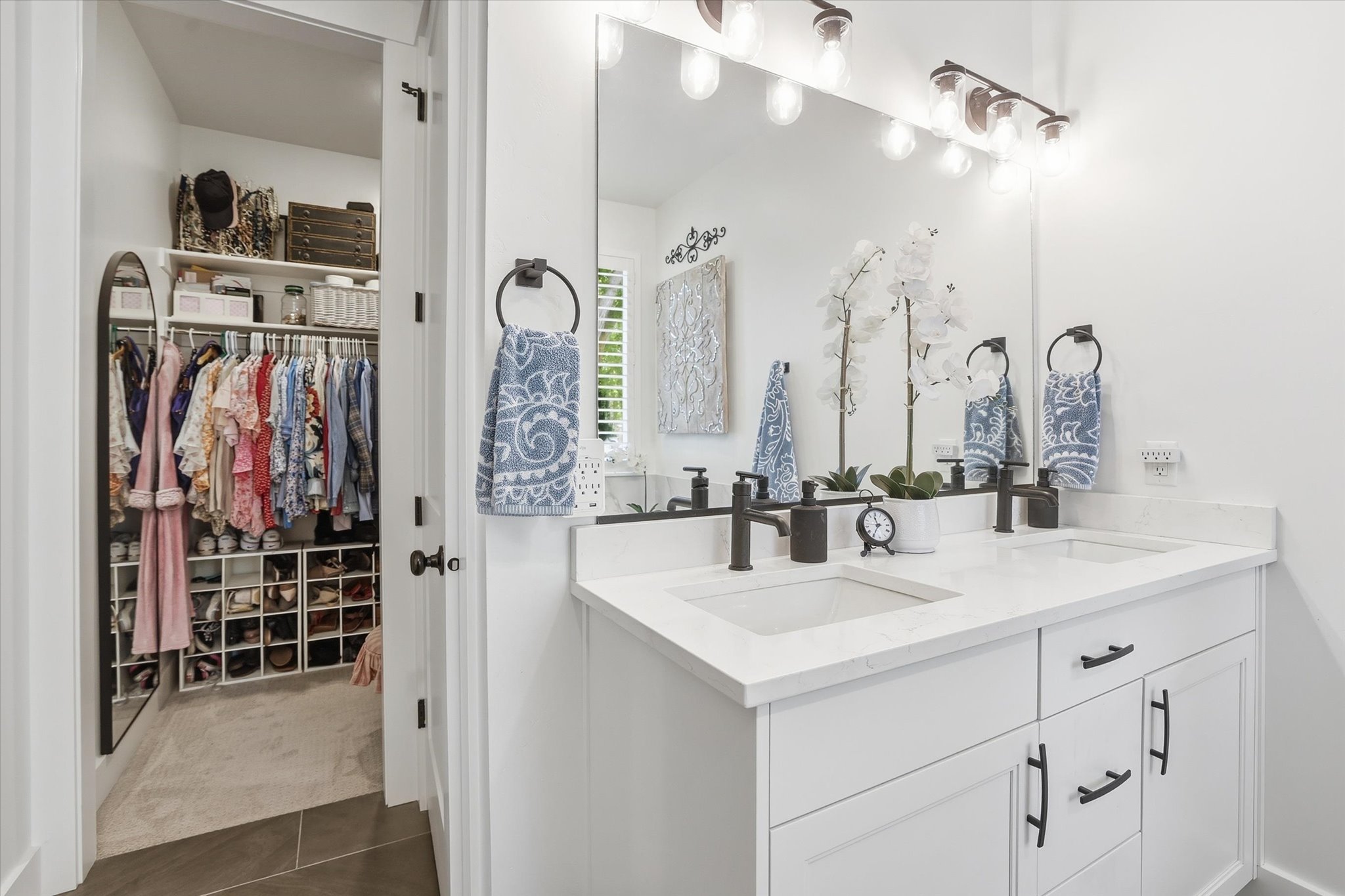 Dual vanity with white cabinetry, quartz countertops, and matte black fixtures