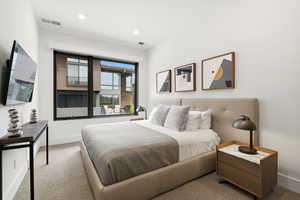 Contemporary bedroom featuring a large picture window, recessed lighting, and neutral wall paint