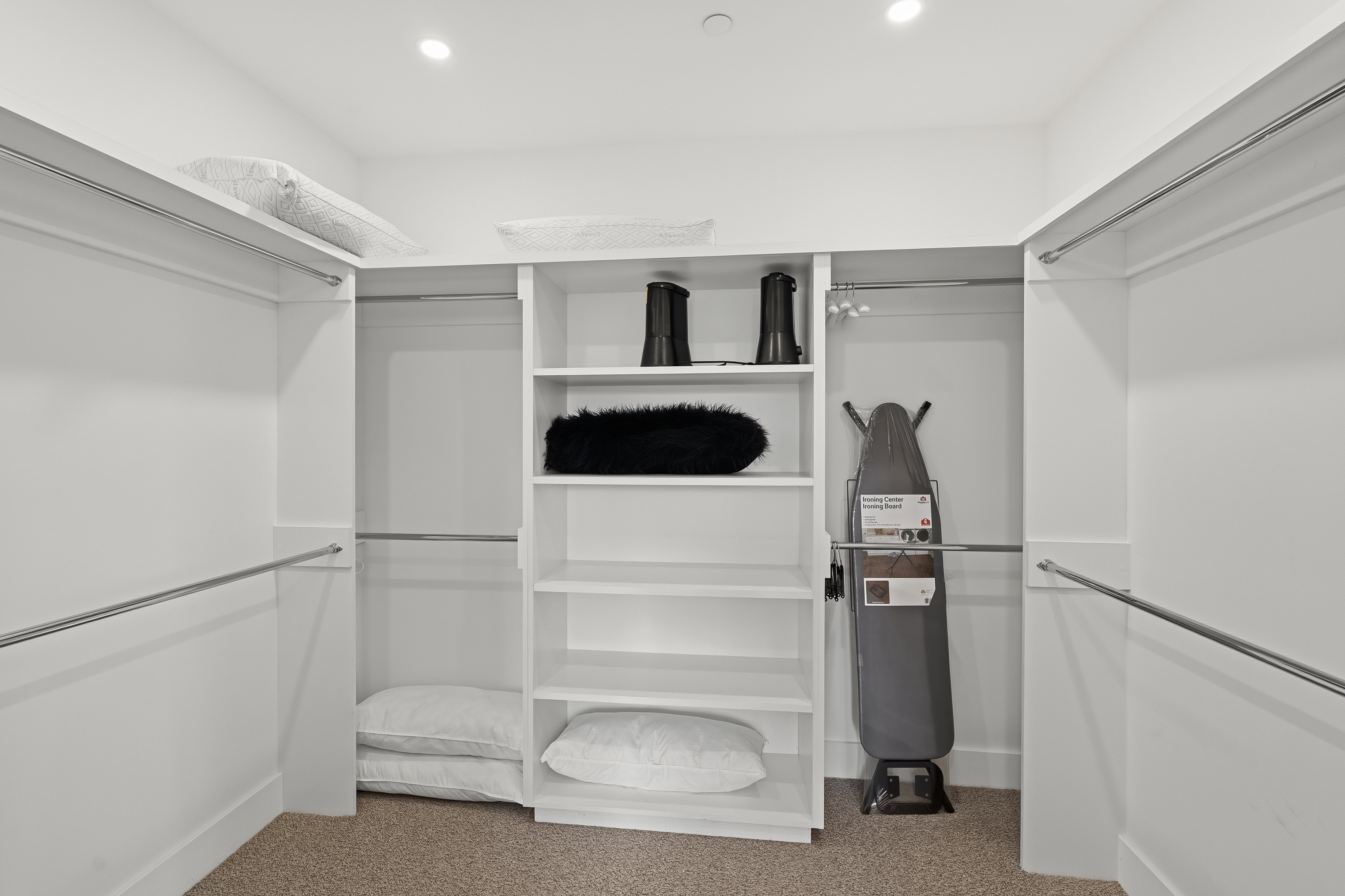 Walk-in closet featuring built-in shelving, multiple hanging rods, recessed lighting, and carpeting