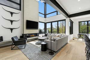 Living area featuring a two-story textured fireplace wall with an integrated linear fireplace
