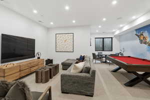 Spacious living room featuring recessed lighting, poker table, pool table, and TV area