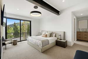 Spacious room featuring a floor-to-ceiling glass sliding door, leading to a private balcony with mountain and tree scenery