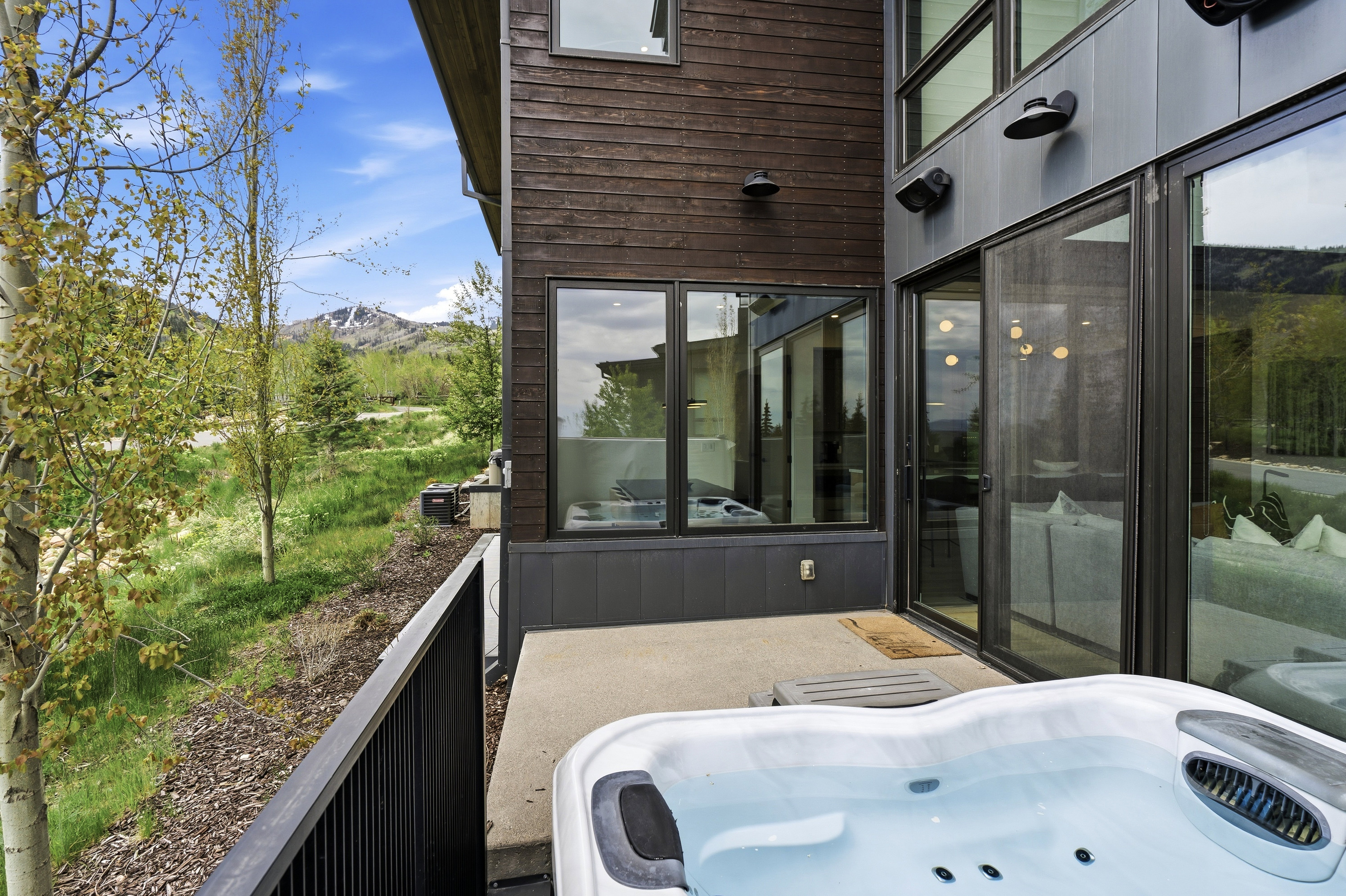 Private patio featuring a hot tub and mountain views.