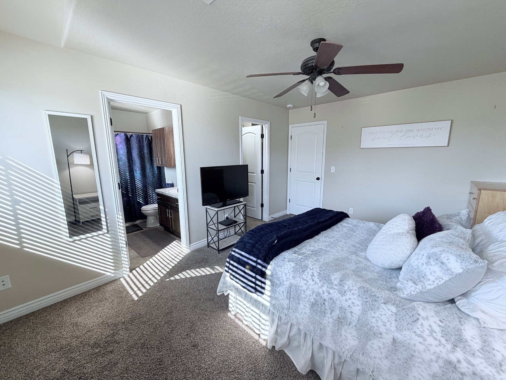 Different view of bedroom #1 featuring an en-suite bathroom with wood-finish cabinetry
