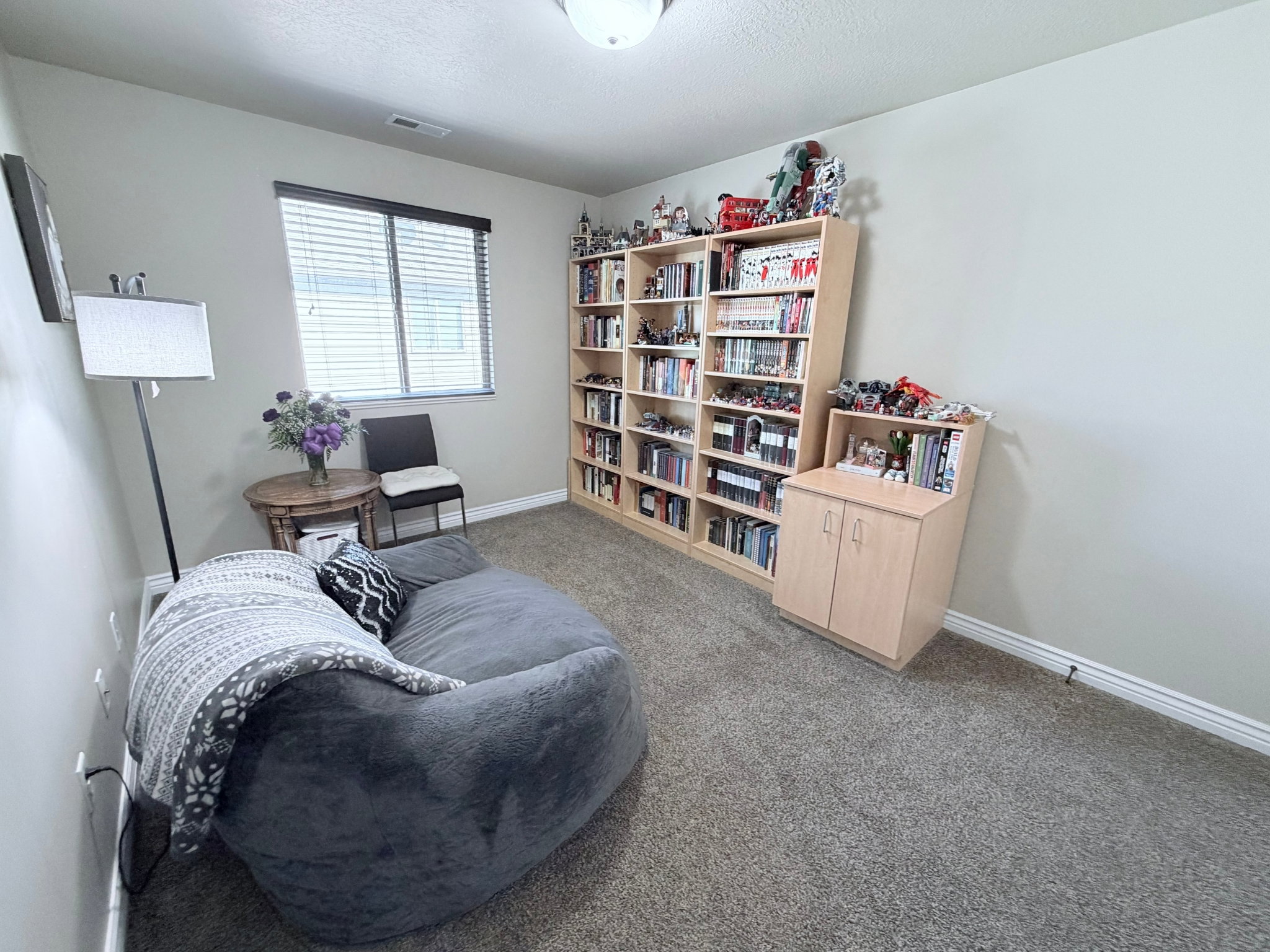 Bedroom #2 with light-colored walls, light carpet and a window with blinds