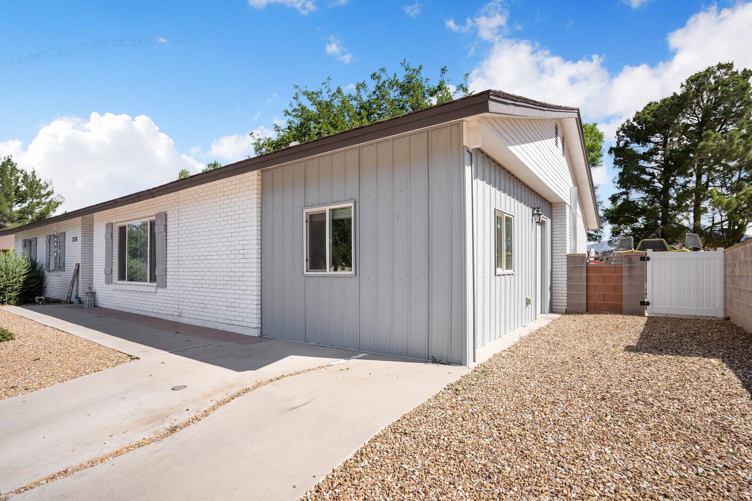 Exterior featuring white painted brick and vertical siding
