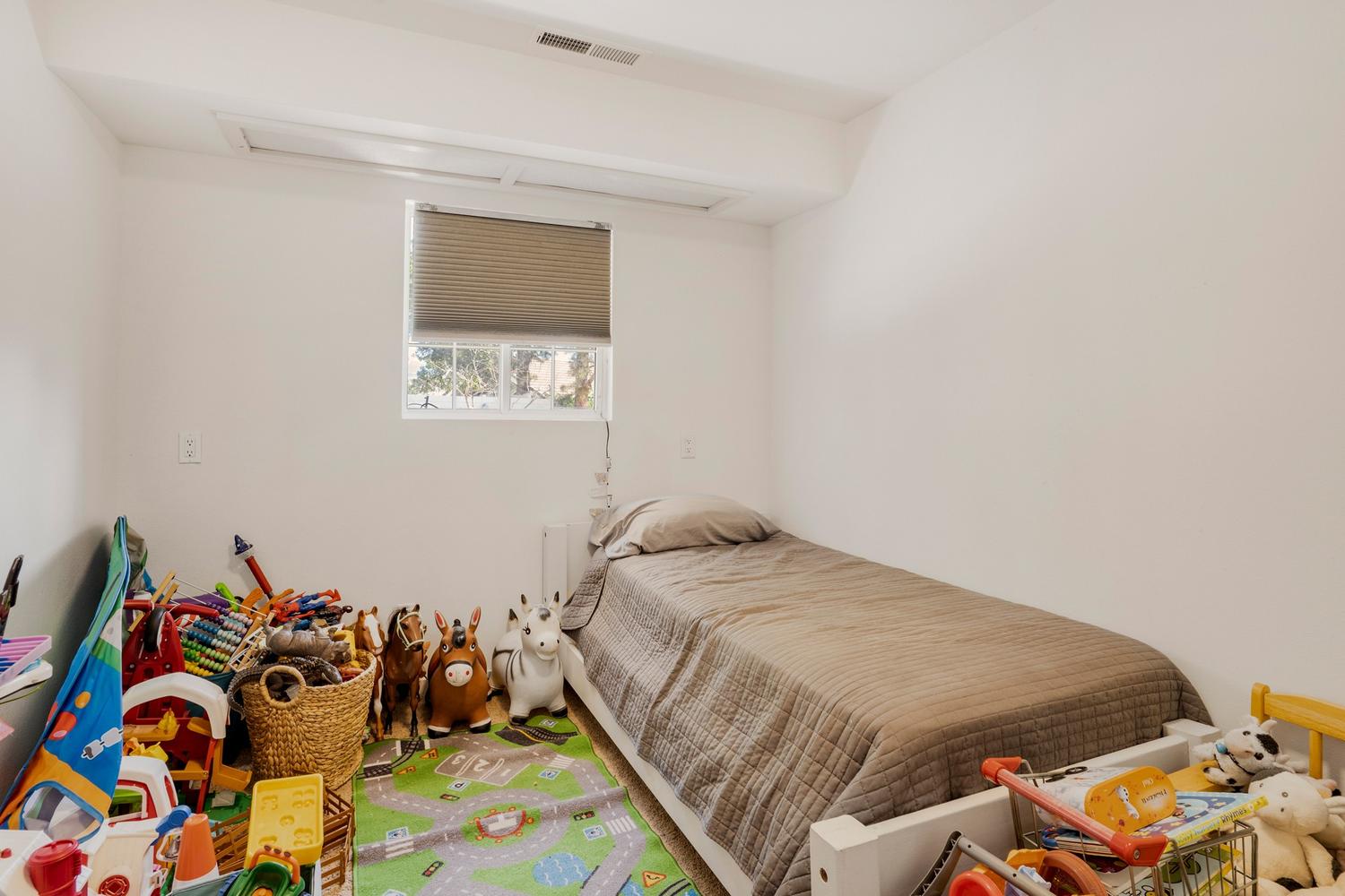 Bright room featuring white walls, a recessed window with blinds, and white trim