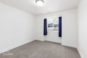 Room featuring neutral carpeting, white walls, and a window with a white frame