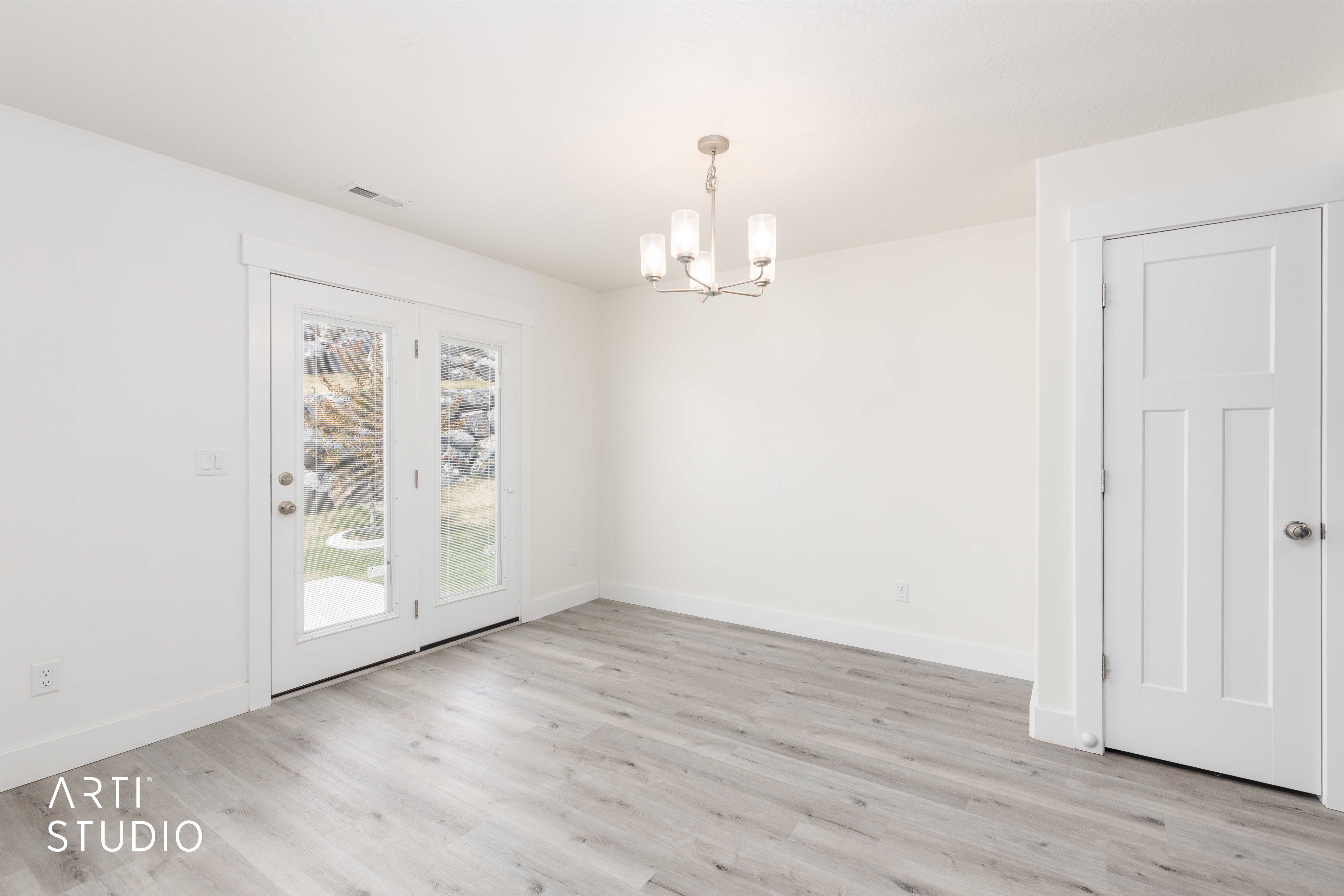 Light wood-finish flooring with white baseboards and walls
