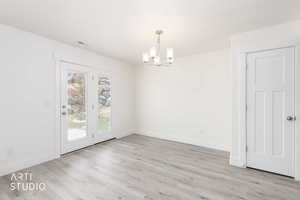 Light wood-finish flooring with white baseboards and walls
